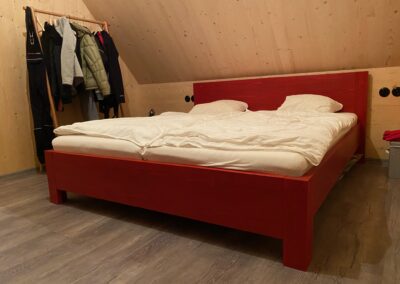 Červená dřevěná postel do chaty