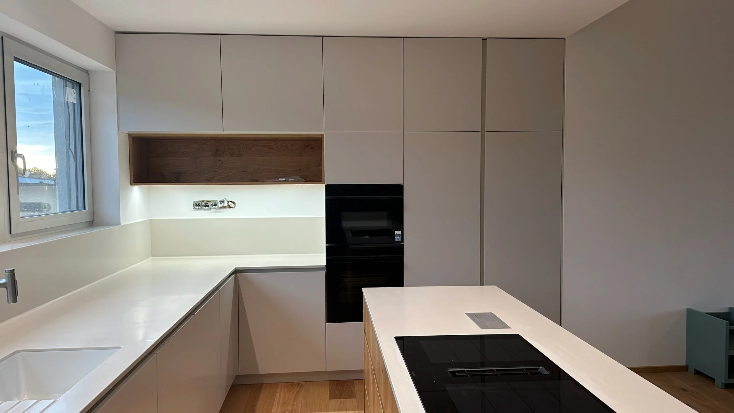 Zakázková kuchyň na míru s bílými korpusy, zelené obklady, dřevěná pracovní deska, projekt budova Bukovinka